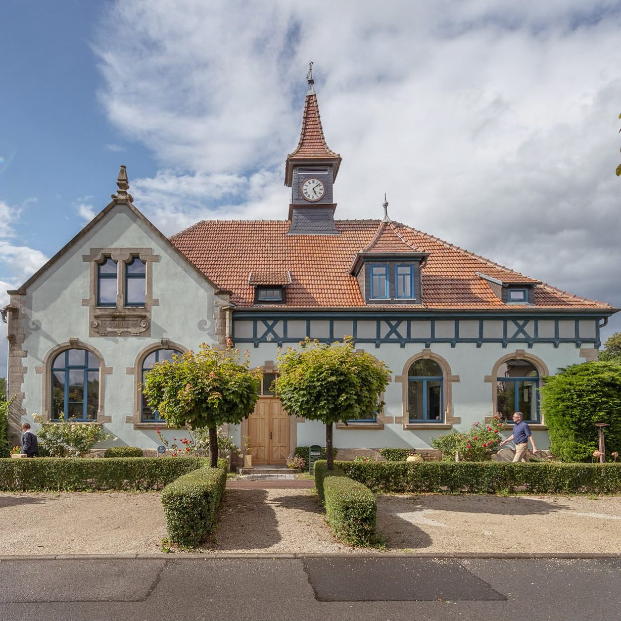 Charmantes Denk Keramik Haus mit Uhrturm, gepflegtem Garten und vorbeigehenden Passanten